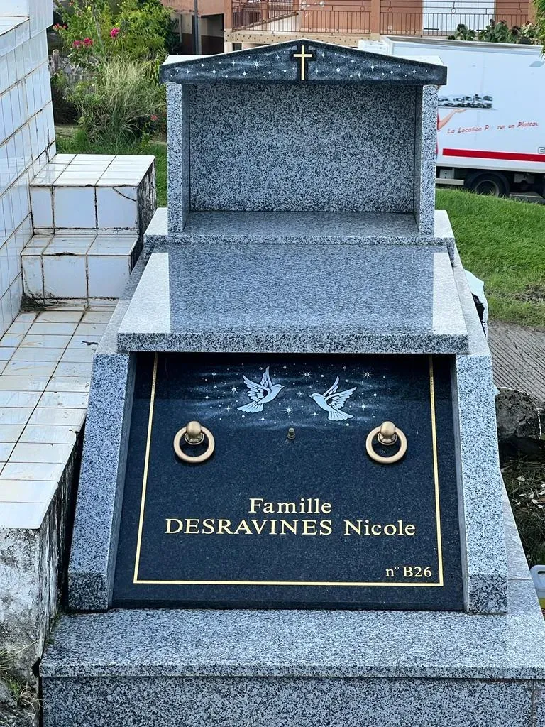 Tombe familiale Desravines Nicole en granit gris avec deux colombes gravées.